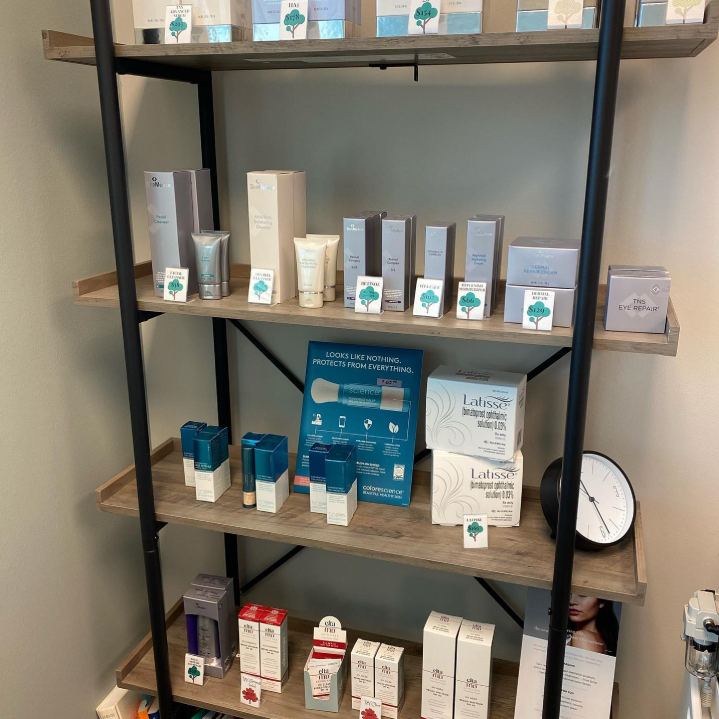 A variety of aesthetic products that are used at Artistry Skin & Laser, neatly and easily viewable on a shelf.